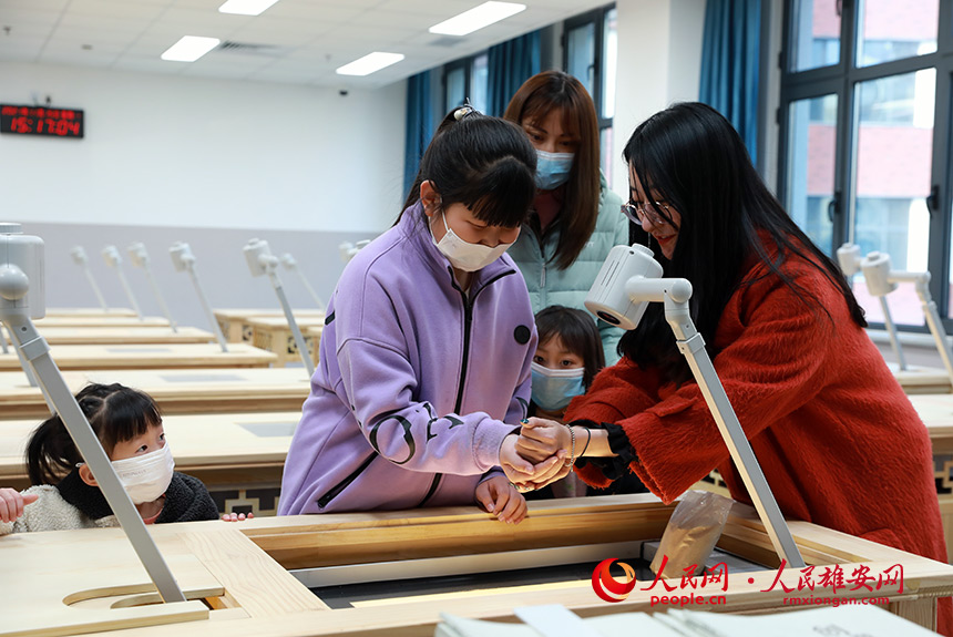 雄安容和樂(lè)民小學(xué)共設(shè)置了26間特色功能教室。圖為參觀學(xué)生正在沙畫教室體驗(yàn)。人民網(wǎng) 宋燁文攝
