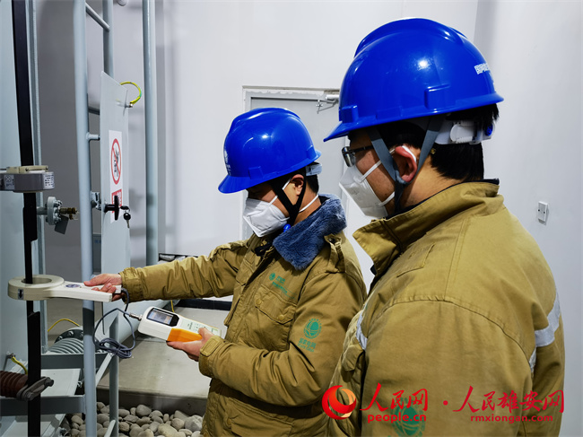 12月15日，國網雄安新區供電公司王濤、樊懷遠正在測量變壓器鐵芯接地電流，確保設備安全投運。張啟光攝