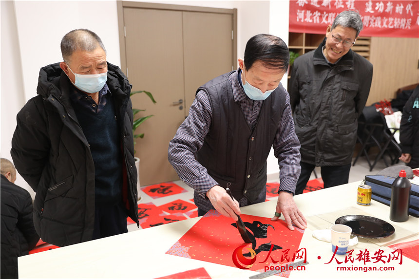 圖為容西片區(qū)愛(ài)水社區(qū)組織寫(xiě)福字、春聯(lián)。人民網(wǎng) 楊華龍攝