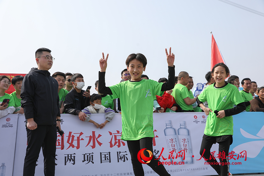 2023雄安半程馬拉松現場，完成健康跑的小選手正在慶祝勝利。人民網 李兆民攝