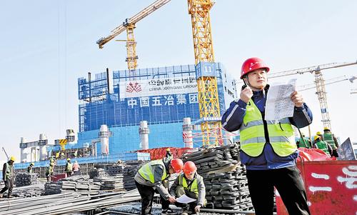 1月20日，雄安城際站及國貿中心項目建設現場，中國五冶集團雄安國貿中心項目常務副指揮長黃紹平(右一）正在進行巡查。本報記者 劉光昱攝