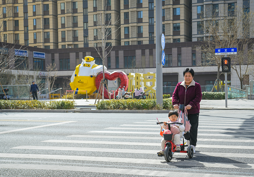 3月12日，居民在雄安新區(qū)容東片區(qū)道路上行走。牟宇攝