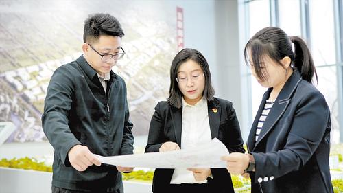 2024年2月，在北京非首都功能疏解中心，夏雨（中）與同事探討項目規劃。受訪者供圖