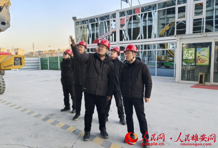 朱懷宇（右一）在雄州站施工現(xiàn)場(chǎng)。人民網(wǎng)記者 唐心怡攝